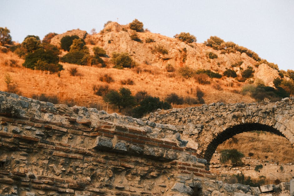 Beautiful ancient ruins with a scenic view of sunlit mountains and rugged terrain.
